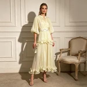 Elegant cream pleated maxi dress featuring tiered ruffles and stylish puff sleeves