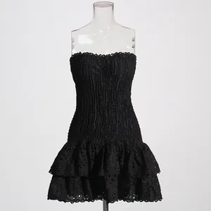 Detailed view of black strapless smocked mini dress with tiered ruffled eyelet hem