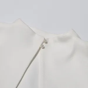Detailopname van de witte jurkkraag met elegante parelknoppen en een stijlvolle split achter.