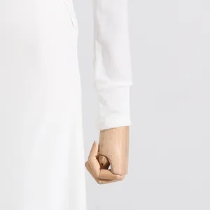 Dettaglio del polsino di un abito lungo in maglia bianca in stile minimalista francese