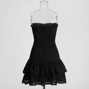 Detailed view of black strapless eyelet lace dress with smocked bodice and ruffles
