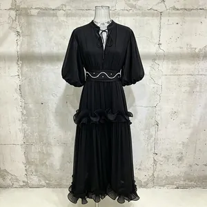 Detailed view of an elegant black French style dress with puff sleeves and ruffles