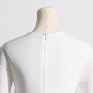 Vista dettagliata della cerniera invisibile sul retro di un abito bianco in maglia