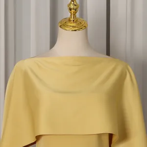 Detail showing the elegant boat neck and yellow cape design of this stylish dress