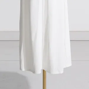 Dettaglio dell'orlo in maglia bianca di un elegante abito lungo stile francese