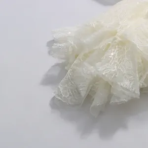 Nahaufnahme von weißer floraler Spitze und Pailletten am ausgestellten Ärmelsaum