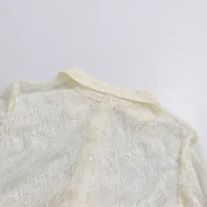 Detailaufnahme eines eleganten weißen Spitzenkragens mit Pailletten-Details