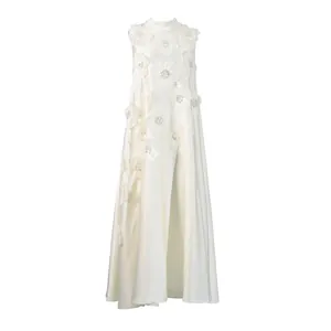 Robe longue évasée blanche sans manches ornée d'appliqués floraux 3D et de perles raffinées.