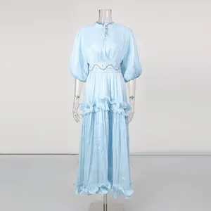 Detail view of the pleated light blue dress with tiered ruffles and puff sleeves