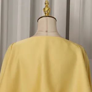 Detailed rear view showing the smooth texture and cape design of this yellow fashion dress