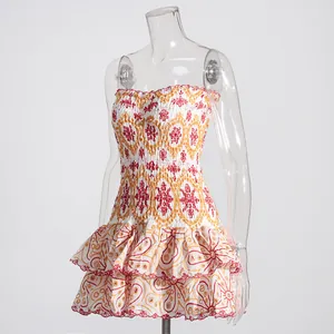 Detailed view of white mini dress with red and yellow heavy embroidery and ruffles