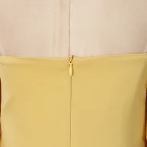 Close-up detail of a yellow dress featuring a matching invisible back zipper design.