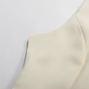 Nahaufnahme eines cremefarbenen Retro-Kleides mit feiner Stoffstruktur und Nähten