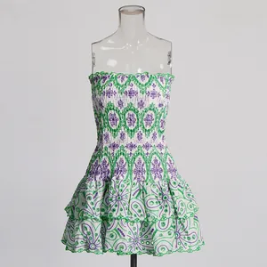 Detailed view of white mini dress with green and purple floral embroidery and tiered ruffles