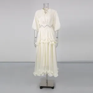 Full view of elegant French style cream dress with puff sleeves and ruffled tiers on mannequin