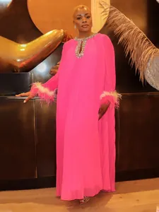 Full view of elegant hot pink pleated maxi dress with rhinestone neck and feather cuffs.