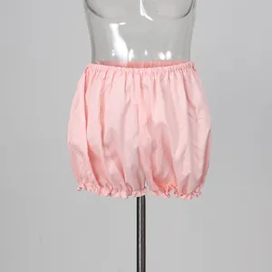 Detail view of light pink ruffled bloomer shorts shown on a transparent mannequin stand