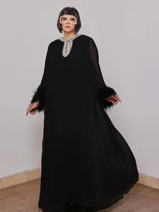 Detailed view of a black plus-size dress with rhinestone collar and ostrich feather cuffs.