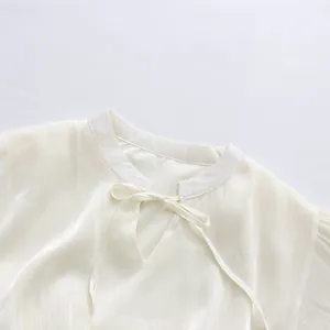 Close-up of white elegant French style dress neckline with tie-neck bow detail