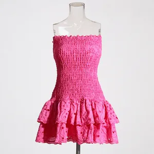 Close-up detail of hot pink smocked tube dress featuring tiered eyelet lace ruffles