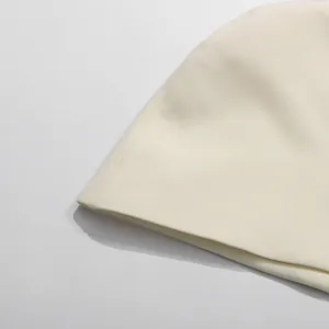 Nahaufnahme der feinen Nähte und der cremefarbenen Stoffstruktur eines eleganten Kleides