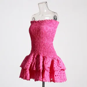 Detail showing pink smocked tube top dress with tiered eyelet lace skirt and slim fit design