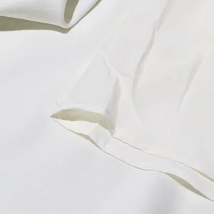 Détail de la couture précise et du tissu blanc de haute qualité de la robe trapèze chic