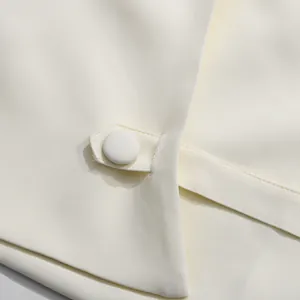 Detailaufnahme des stoffbezogenen Knopfes und der Taillenlasche an diesem eleganten Kleid