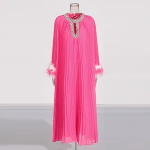 Detailed view of rhinestone neckline and ostrich feather cuffs on pink maxi dress