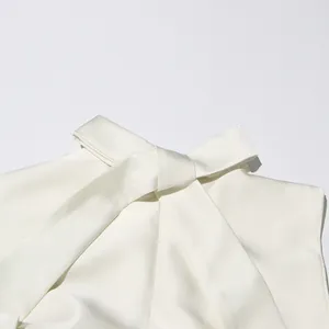 Gros plan du col d'une élégante robe en satin blanc avec un grand nœud papillon et col haut