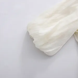 Macro detail of white puff sleeve showing textured fabric on French elegant summer dress.
