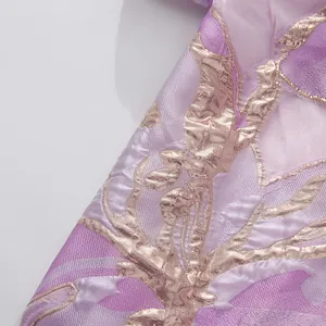 Primo piano di elegante tessuto viola con dettagli in ricamo jacquard floreale oro
