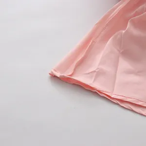 Detailed view of the neat stitching and soft pink fabric on this French style dress