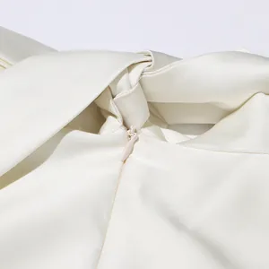 Détail en gros plan de la fermeture éclair invisible et de la texture satinée d'une robe