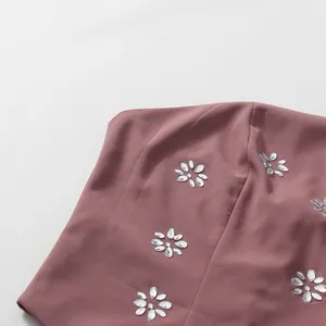 Detailed view of the mauve fabric on a French style dress with rhinestone flowers
