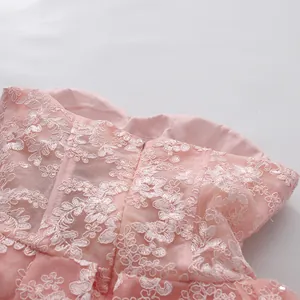Close-up view showing the intricate pink floral lace embroidery on a strapless dress