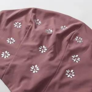 Close-up of elegant floral rhinestone patterns on a mauve French court style dress detail.