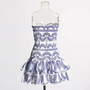 Gedetailleerd overzicht van witte strapless mini-jurk met blauw borduurwerk en ruches