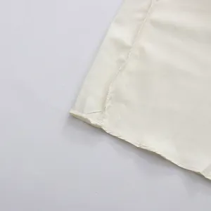 Close-up detail of cream French style elegant dress showing hemline and stitching