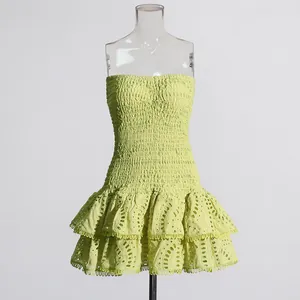 Detail van een limoengroene strapless jurk met gesmockt lijfje en ruches aan de rok