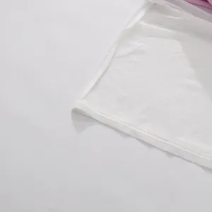 Primo piano delle cuciture sottili e del tessuto a rete di un abito lungo a fiori bianco.
