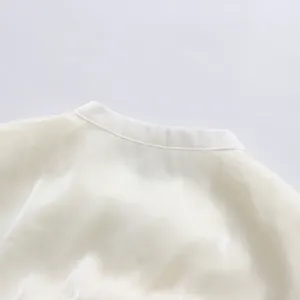 Close-up detail of the elegant round neckline on a white sheer French style dress.