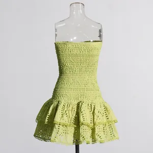 Gedetailleerde weergave van een limegroene strapless jurk met gelaagde oogjes ruches