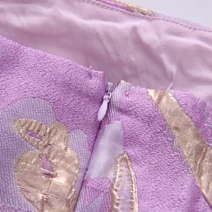 Vista ravvicinata di una cerniera invisibile di alta qualità su un abito estivo viola a fiori