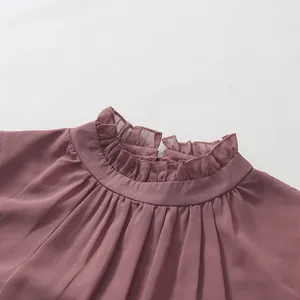 Close-up of mauve French style dress with ruffled wood ear high collar and pleated neckline