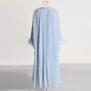 Rear view of light blue pleated maxi dress with ostrich feather cuffs and rhinestones