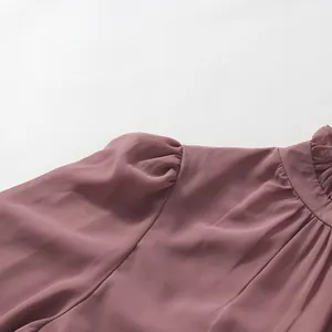 Close-up of elegant puff sleeves and ruffled high neck on a mauve French style dress