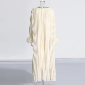 Back view of cream pleated long dress with rhinestone collar and ostrich feather cuffs