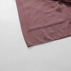 Detail of dusty rose French style dress hem showing fine stitching and soft fabric.