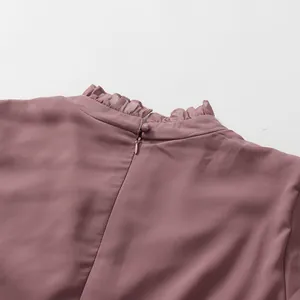 Detail of ruffled high neck and hidden back zipper on a dusty rose French style dress